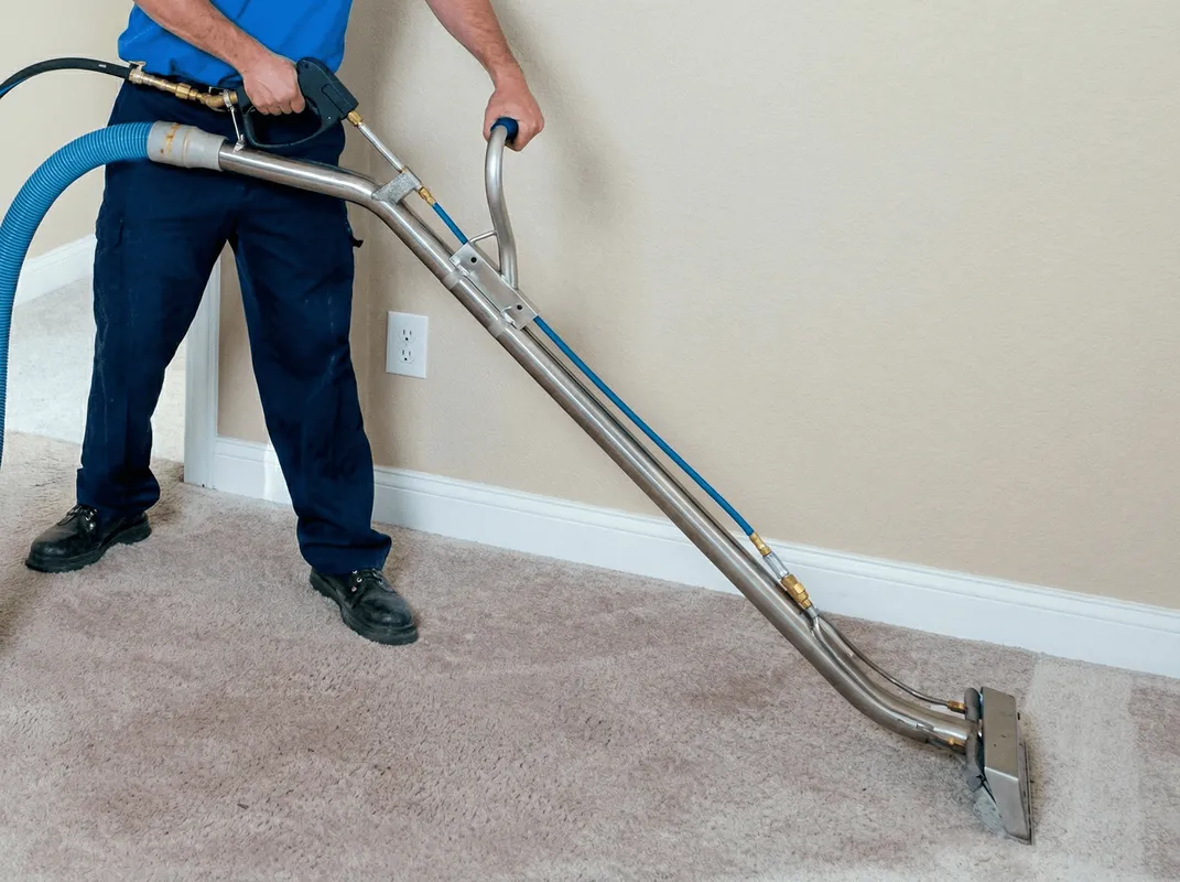 Professional operating a liquid removal machine on a carpeted floor in Irvine, CA